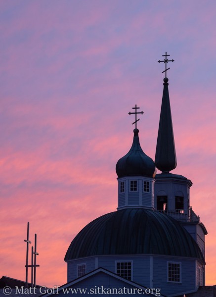 Crosses of St. Michael's and the Lutheran Church against a pink sky