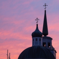 Crosses of St. Michael's and the Lutheran Church against a pink sky